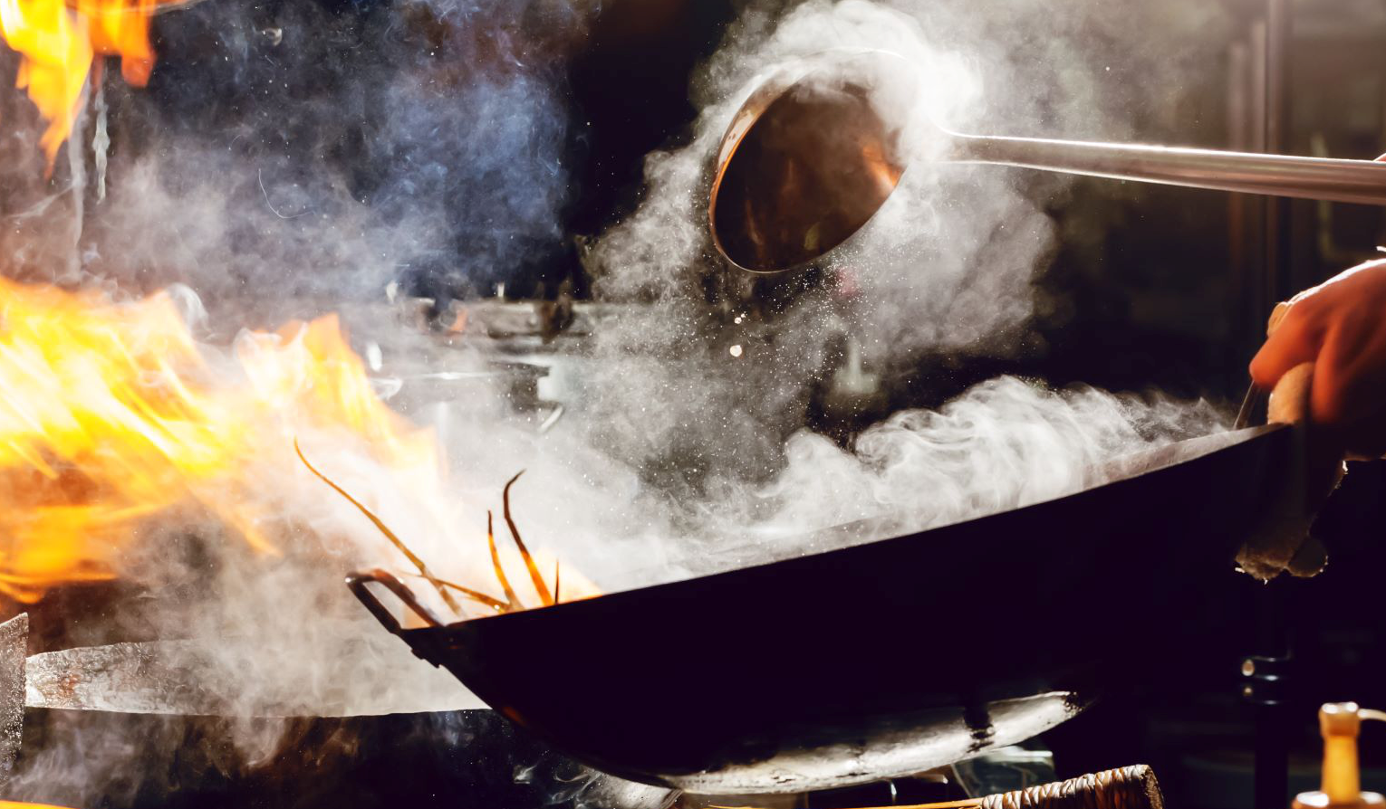 An image of a chef cooking with a wok